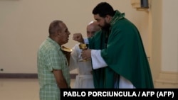 George Payano, fraile de los Carmelitas Descalzos, administra la comunión en convento de Santa Teresa y San José en La Habana. Foto: PABLO PORCIUNCULA / AFP