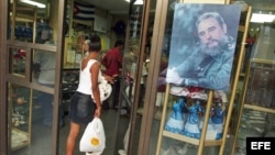 Archivo - Una mujer entra en una tienda en La Habana. 