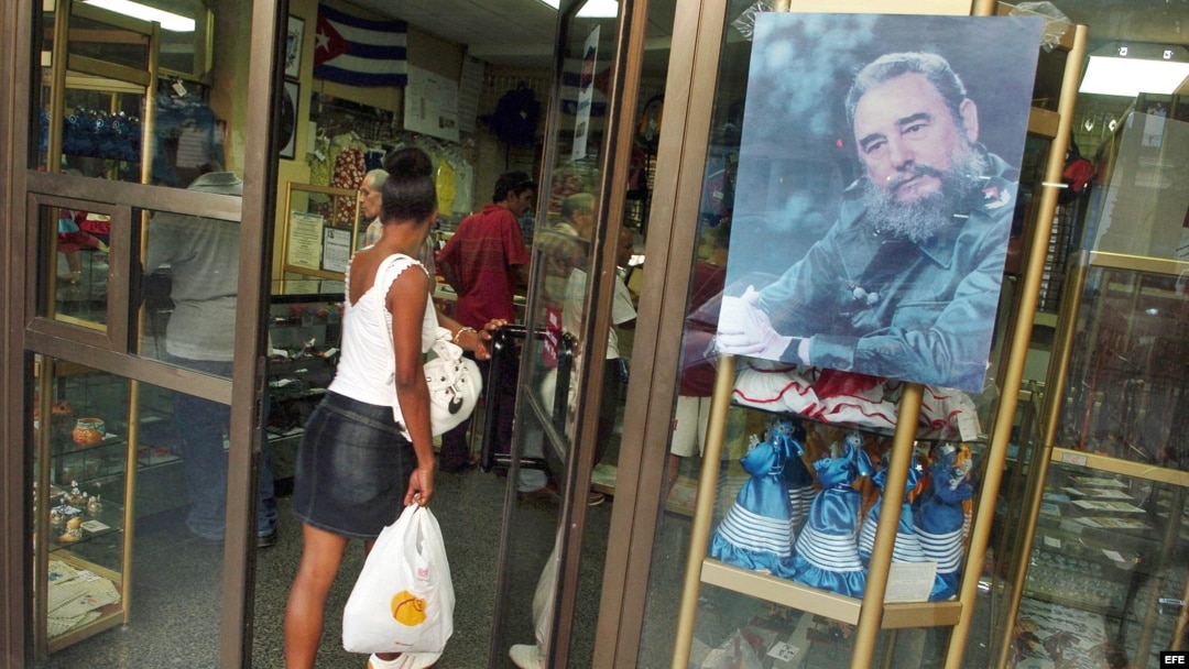 Archivo - Una mujer entra en una tienda en La Habana. 