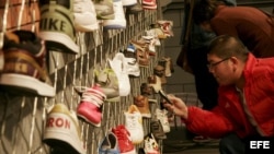 Un joven de Shangai, China, fotografía con su móvil algunas de las zapatillas deportivas. 