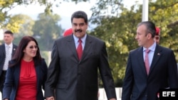 El presidente venezolano, Nicolás Maduro (c), camina junto a su esposa, Cilia Flores (i), y a Tareck El Aissami (d) en un acto de gobierno hoy, 4 de enero de 2017.