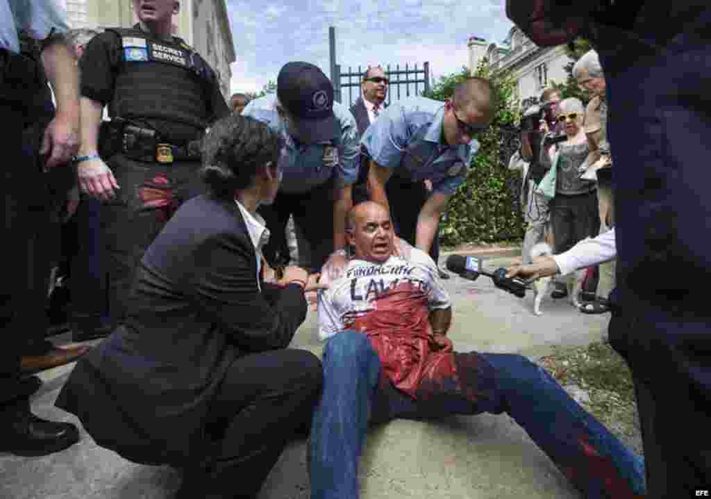 Un manifestante es detrenido tras el izamiento de la bandera cubana en la embajada del país en Washington.