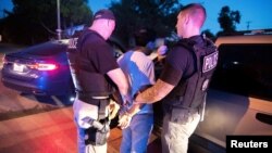 Oficiales de Inmigración y Control de Aduanas detienen a un hombre en Sherman, Texas. 