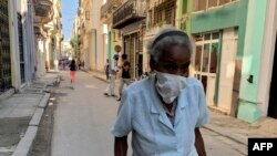 Una anciana con mascarilla protectora por el COVID-19 camina por una calle de La Habana. (ADALBERTO ROQUE / AFP)