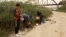 Un grupo de migrantes de Cuba revisa sus teléfonos poco después de cruzar el Río Grande en Eagle Pass, Texas, el 18 de diciembre de 2022. 