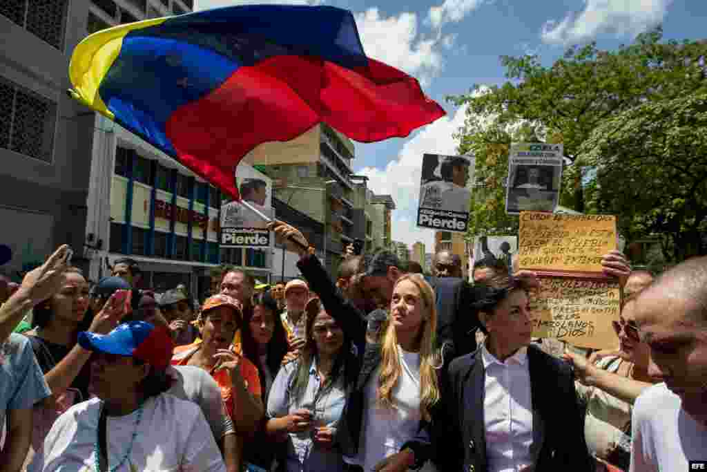  La esposa del líder opositor venezolano Leopoldo López Lilian Tinytori (c) ondea una bandera de Venezuela hoy, viernes 4 de septiembre de 2015, a su llegada al Palacio de justicia en Caracas. EFE