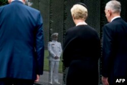 El teniente de Marina Jack McCain, hijo del John McCain, se refleja en el muro que recoge los nombres de los caídos en Vietnam.