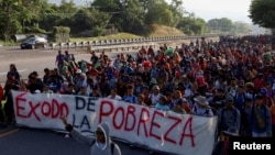 Los migrantes caminan en una caravana, algunos de ellos sosteniendo una pancarta que dice "Éxodo de la pobreza", como un intento de llegar a la frontera con Estados Unidos, en Huixtla, México, el 26 de diciembre de 2023. REUTERS/José Torres