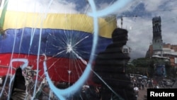 La bandera venezolana es vista a través de un cristal roto durante una manifestación contra Nicolás Maduro en Caracas. (Archivo)