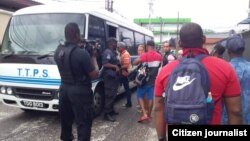 Autoridades migratorias de Trinidad Tobago desalojan en autobuses a más de 80 cubanos que estaban acampados en protesta frente a la sede local de la ACNUR (Jacqueline Vera) 