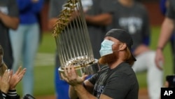 El tercera base de los Dodgers de Los Ángeles, Justin Turner, celebra con el trofeo luego de derrotar 3-1 a los Rays de Tampa Bay para ganar la Serie Mundial de béisbol.