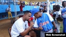 José "Pito" Abreu firma la camiseta de un niño cubano durante la Clínica de béisbol. Foto publicada por la prensa oficialista.