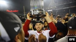 El jugador de los Medias Rojas de Boston Stephen Drew alza el trofeo después de vencer por 6-1 a los Cardenales de San Luis en el sexto partido de la Serie Mundial (4-2 al mejor de los siete encuentros), un resultado con el que se proclamaron los nuevos c