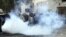  Agentes de policía antidisturbios egipcios, tratan de protegerse de los gases lacrimógenos lanzados por los manifestantes durante una protesta contra el "decretazo" del presidente egipcio, Mohamed Morsi. 