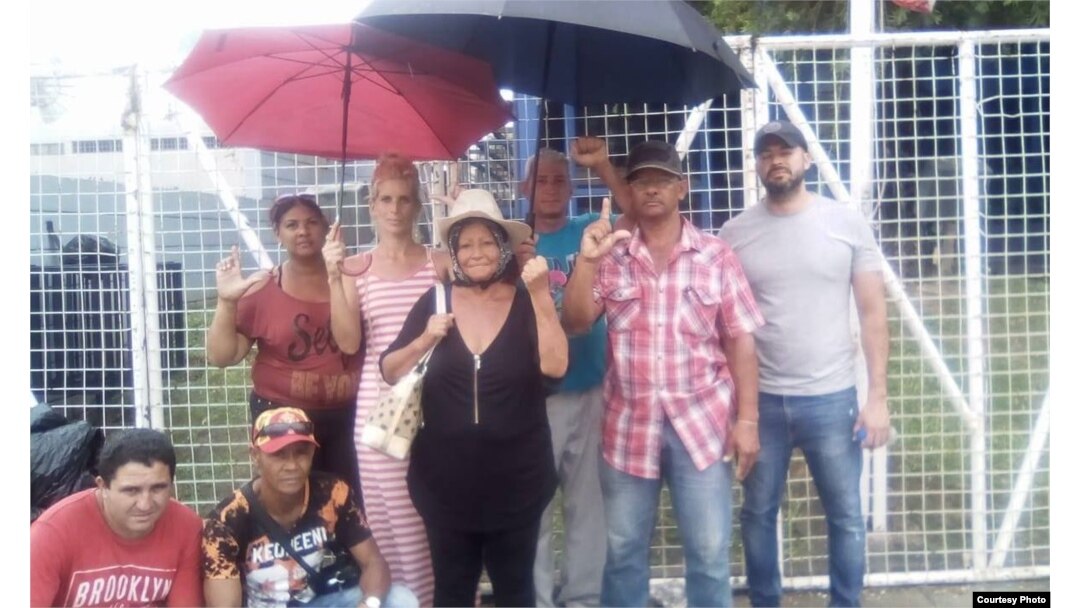 Onelia, al centro con sombrero, posa junto a otros cubanos en Trinidad y Tobago.