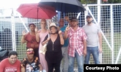 Onelia, al centro con sombrero, posa junto a otros cubanos en Trinidad y Tobago.