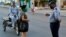 Un policía hace chequeos de peatones el sábado en el barrio El Carmelo, que el gobierno anunció inicialmente que iba a aislar y luego mantuvo abierto por temor a que se hiciera aún más difícil el acceso a provisiones, según reporta el diario 14ymedio (Foto: Yamil Lage/AFP).