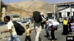 Familias sirias cruzan la frontera libanesa con Siria desde el punto de Al Masnaa, Líbano,