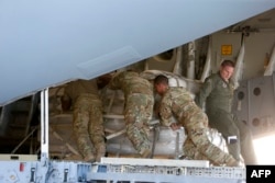 Soldados estadounidenses cargan ayuda humanitaria a Venezuela.