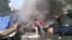 Varios iraquíes sujetan mangueras para tratar de apagar el fuego causado por un coche bomba en un distrito de Bagdad, Irak hoy, lunes 27 de mayo de 2013. 