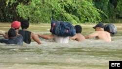 Fotografía cedida por la Agencia Quadratín, que muestra a un grupo de habitantes mientras nada por una zona inundada por el río Guamol, en Itsmo de Tehuantepec (Oaxaca, México).