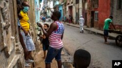 Cubanos conversan protegidos con mascarillas. AP Photo/Ramon Espinosa, File)