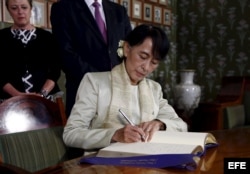 La opositora birmana Aung San Suu Kyi firma en el libro de honor en la sede del Instituto Nobel en Oslo, Noruega, el sábado 16 de junio de 2012