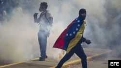 Manifestantes se enfrentan con integrantes de la Policía Nacional Bolivariana durante una protesta contra el gobierno del presidente venezolano Nicolás Maduro hoy, miércoles 12 de marzo del 2014, en la Universidad Central de Venezuela (UCV) en Caracas (Venezuela).