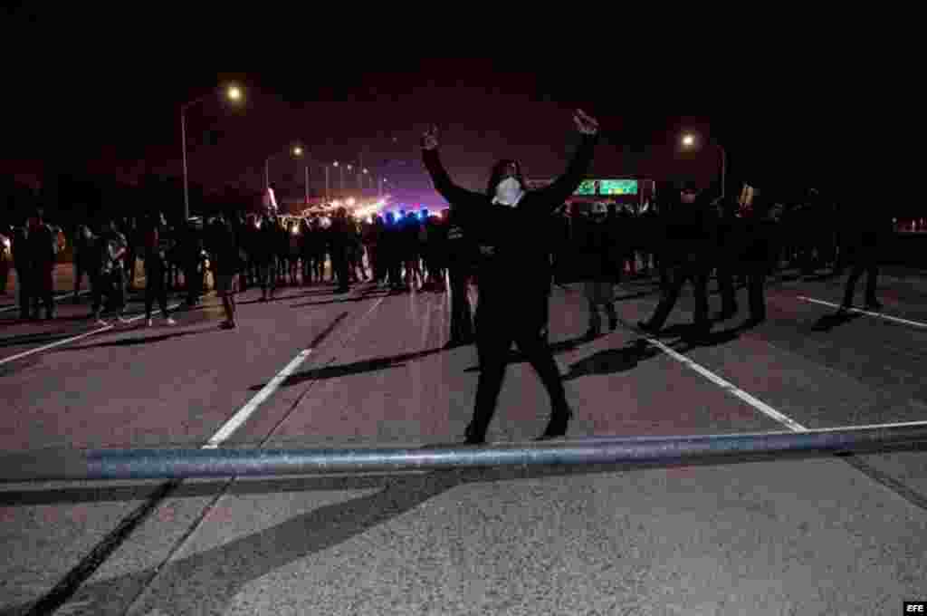 Un manifestante celebra tras haber ayudado a volcar una farola para cortar una carretera mientras varios activistas bloquean el tráfico en la autopista HWY 580 durante una protesta en Oakland, California, contra la elección del republicano Donald Trump como presidente de EEUU. &nbsp;