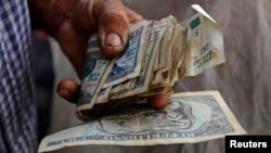 Un hombre sostiene pesos cubanos. REUTERS/Desmond Boylan