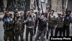 Varios miembros del ejército rebelde ostrando sus armas y gritando consignas en contra del régimen del presidente sirio, Bachar al Asad en la ciudad de Alepo, Siria. 