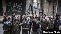 Varios miembros del ejército rebelde ostrando sus armas y gritando consignas en contra del régimen del presidente sirio, Bachar al Asad en la ciudad de Alepo, Siria. 