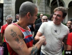 El líder del grupo musical puertorriqueño Calle 13, el cantante René ("Residente") Pérez (i), saluda a Antonio Castro.