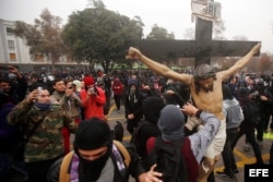 Manifestantes remueven el crucifijo de la Iglesia de la Gratitud Nacional hoy, jueves 9 de junio de 2016, en una protesta de miles de estudiantes.