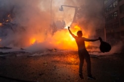 Manifestante en Santiago de Chile festeja la quema de la Iglesia de la Asunción.