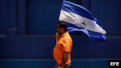 Manifestante enarbola la bandera nicaragüense durante una protesta en Managua. (Archivo)