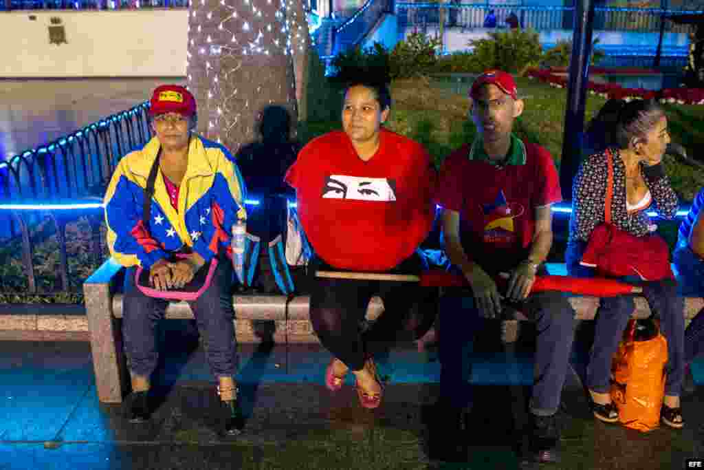 Algunas personas esperan en las inmediaciones del comando Bolivar-Chávez en Caracas (Venezuela), que agrupa a los partidos del oficialismo.
