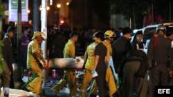 Miembros de los servicios de emergencias traslandan un cadáver en el lugar donde ha explosionado una bomba junto a un templo budista en Bangkok, Tailandia, hoy, 17 de agosto de 2015. 