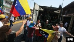 Manifestantes gritan consignas a un grupo de policías en San Cristobal (Archivo)