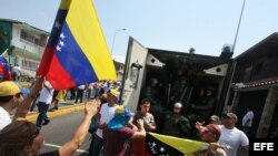 Manifestantes gritan consignas a un grupo de policías durante una marcha contra el gobierno de Nicolás Maduro en San Cristobal, Venezuela