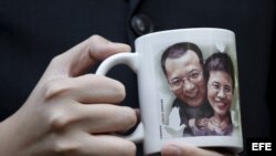 Un activista pro democrático muestra un retrato del disidente chino Liu Xiaobo y de su esposa Liu Xia. 