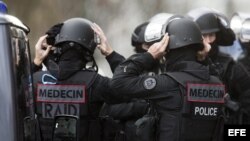 Unos agentes de la policía francesa y miembros del equipo médico de las fuerzas especiales de la policía francesa RAID y BRI se preparan para intervenir después de que un hombre fuertemente armado tomara varios rehenes en una oficina de correos al oeste d