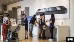 Clientes observan diversos dispositivos en oferta en una tienda Apple en Pekín (China). 