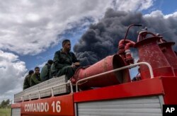 Bomberos se desplazan hacia el lugar del incendio, en la base de supertanqueros de Matanzas. (AP/Ramon Espinosa)