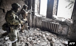Soldados ucranianos entre las ruinas del teatro bombardeado por Rusia en la ciudad de Mariúpol