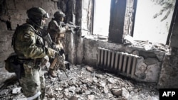 Soldados ucranianos entre las ruinas del teatro bombardeado por rusos en la ciudad de Mariúpol. (Photo by Alexander NEMENOV / AFP).