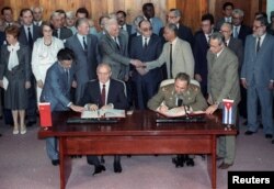 Gorbechev y Castro firman un convenio mientras el canciller soviético, Edward Shevardnadze, saluda a Juan Almeida, el 4 de abril de 1989.