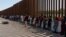 Migrantes de Venezuela y Cuba esperan ser transportados por agentes de Aduanas y Protección Fronteriza de EEUU en Eagle Pass, Texas.