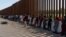 Migrantes de Venezuela y Cuba esperan ser transportados por agentes de Aduanas y Protección Fronteriza de EEUU en Eagle Pass, Texas.