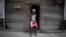 Una mujer que vende bolsas de plástico espera por clientes en La Habana. En medio de la escasez de casi todo, el dengue cobra fuerza. (AP Foto/Ramon Espinosa)